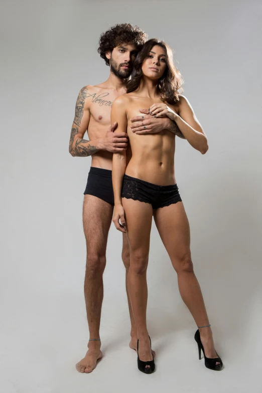 man and woman posing shirtless in black underwear