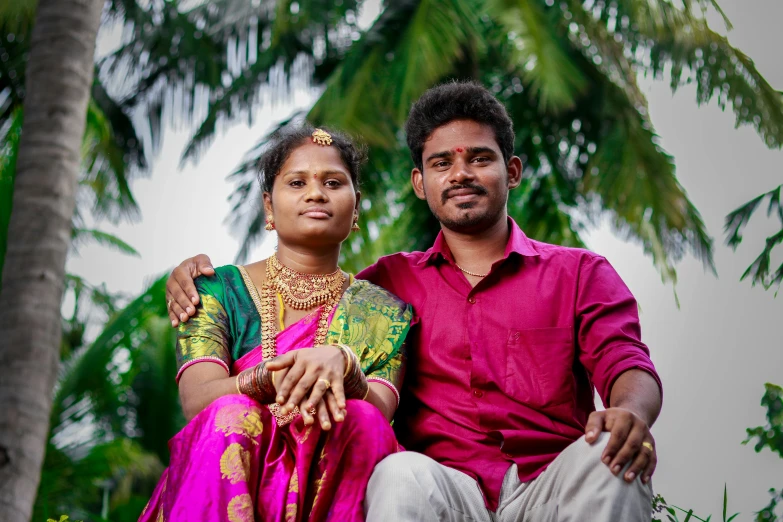 a man and woman wearing a pink shirt are sitting next to each other