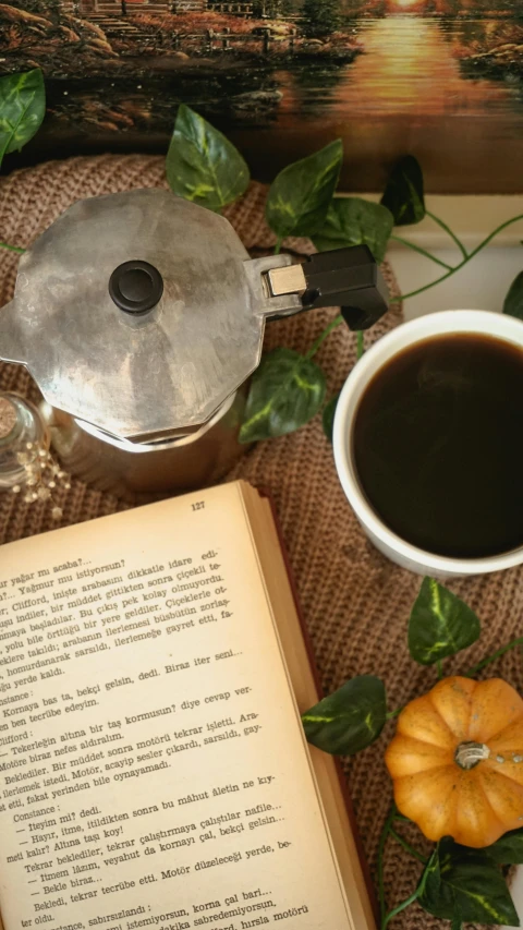 a book, cup of coffee, and cup of tea on a table