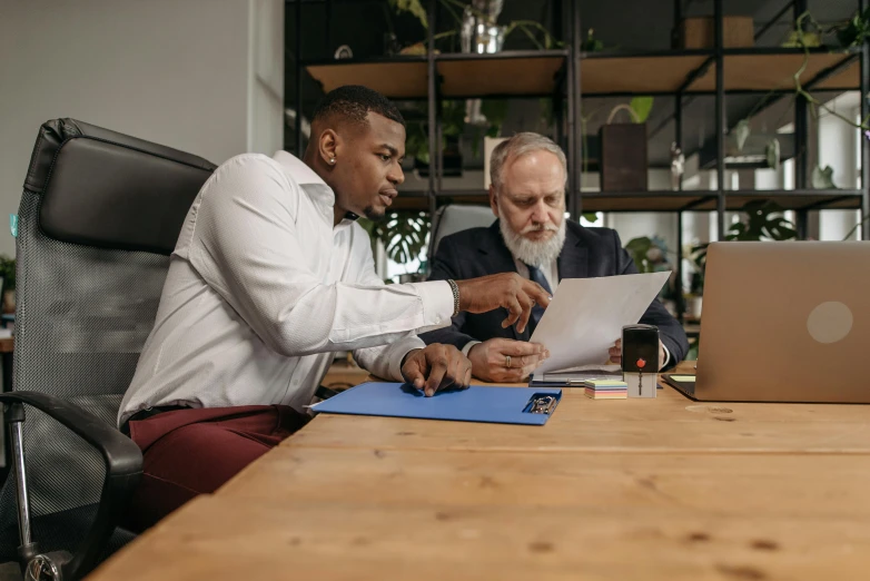 two men at a table working on soing