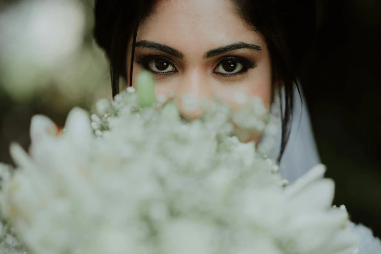 an attractive girl peeking out over the flower stems