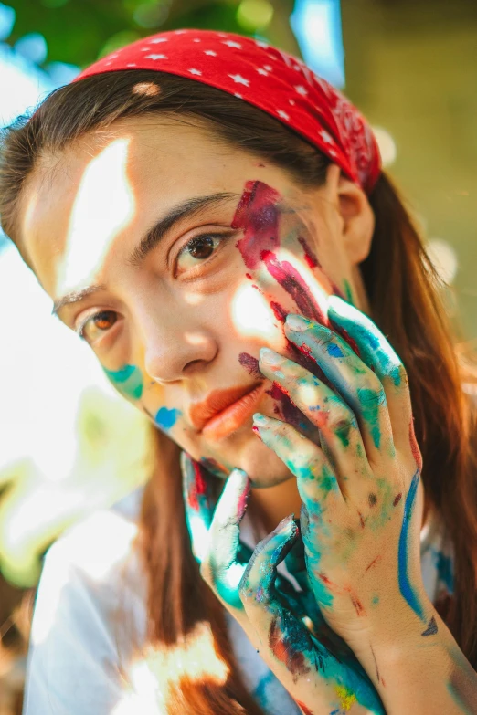 an attractive young woman is wearing colorful face paint