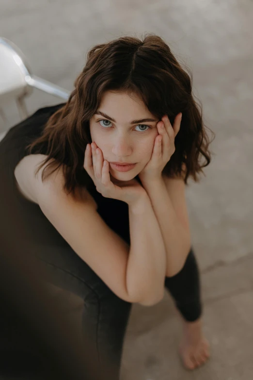 a woman posing for a portrait with her chin under her hand