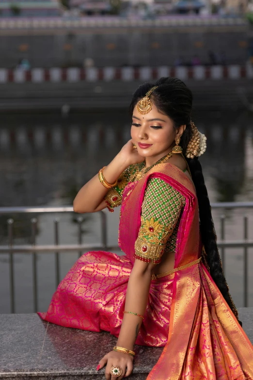 a woman with a red and gold sari and a big smile