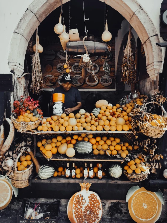 a fruit stand with oranges, onions and other items in baskets