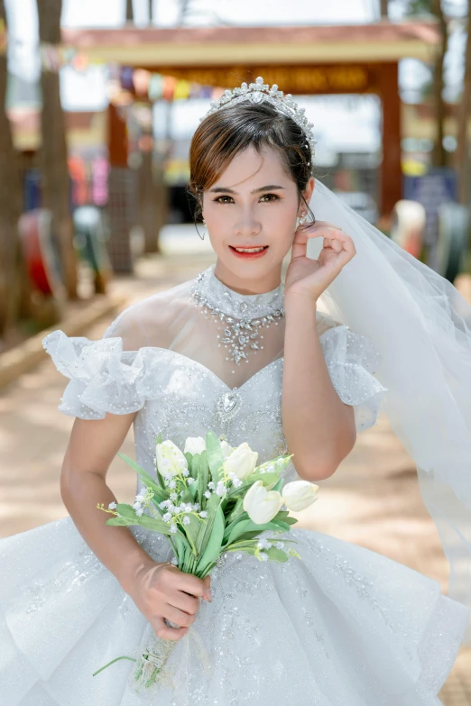 a woman in white holding a bouquet and posing for a picture