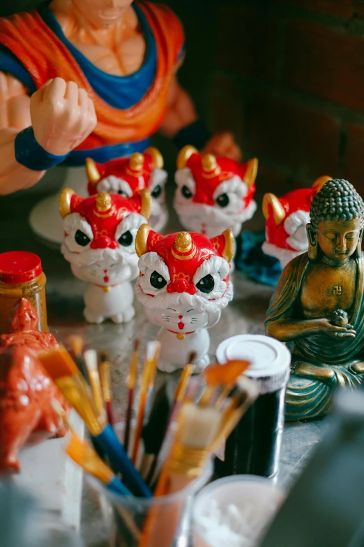 statues and statues on a table with writing utensils