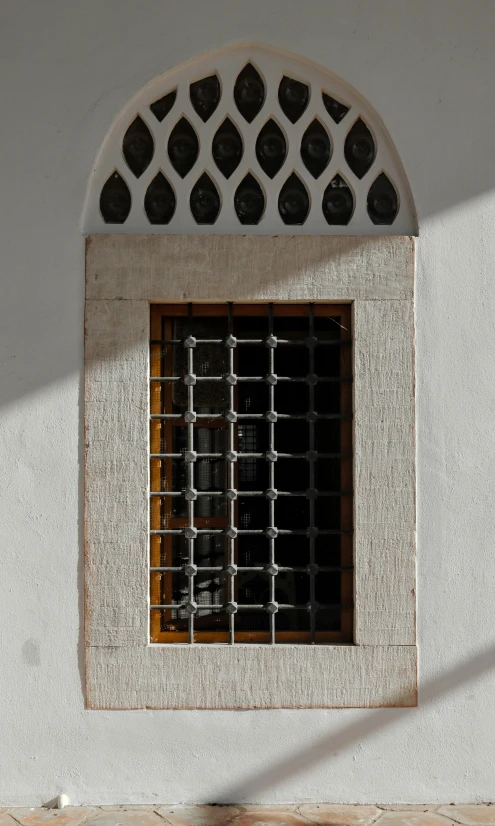 a tall window next to a wall with a screen above it