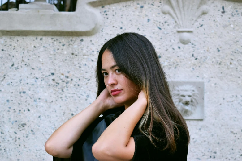 a women that is standing in front of a wall