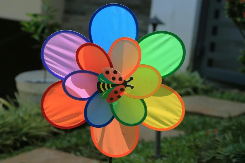 colorful colored wind spinner has a lady bug on it