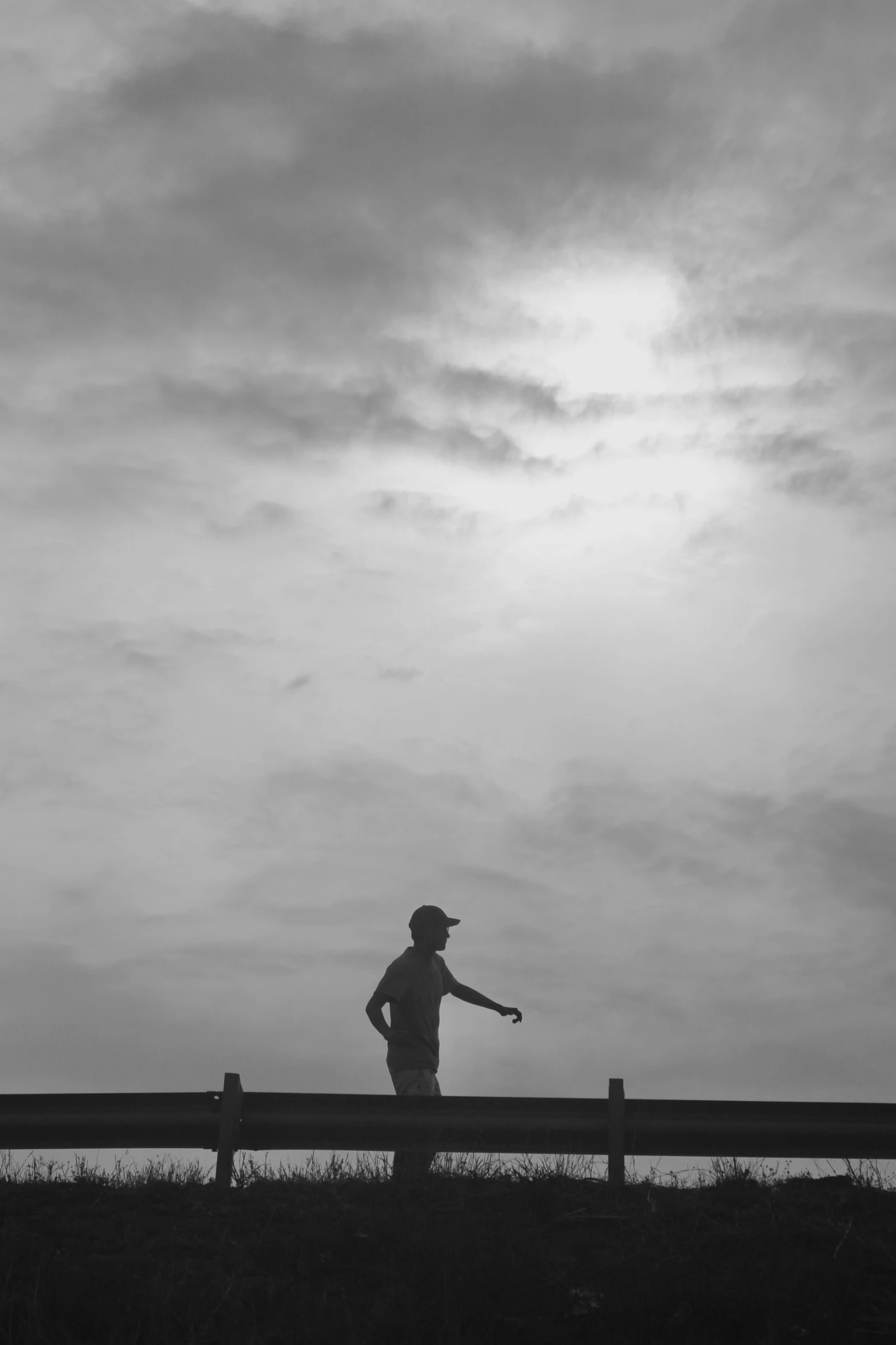 a black and white po of a person standing on a boardwalk