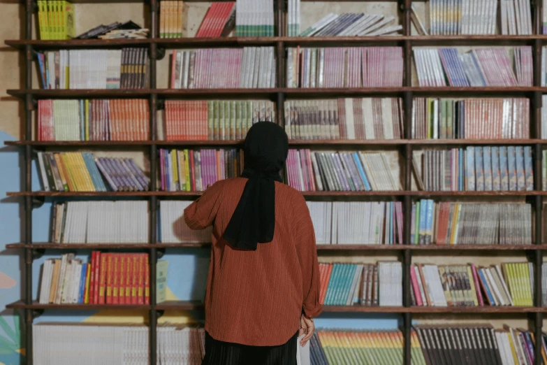the back end of a person standing in front of book shelves