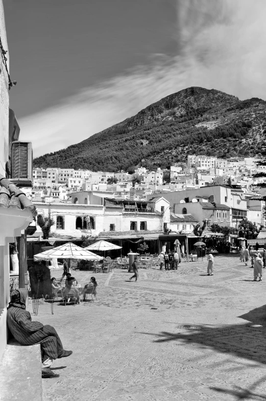 black and white pograph of people sitting in chairs on the beach