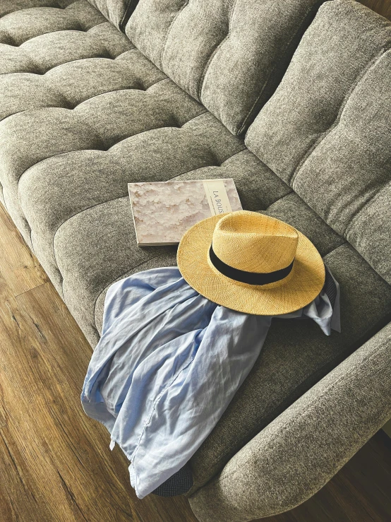 a yellow hat sitting on top of a beige couch