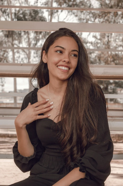 a beautiful woman sitting on a bench and smiling