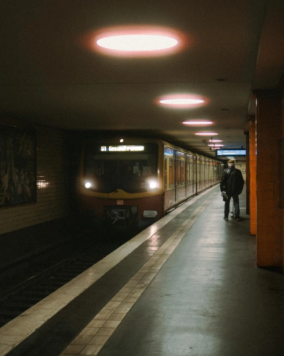 an empty subway station with a train pulling up to it