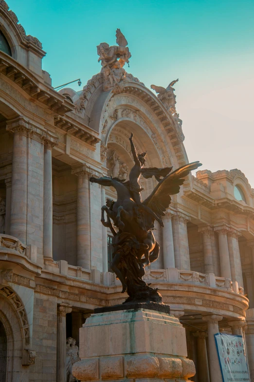 statue on pedestal outside very ornate building in daylight