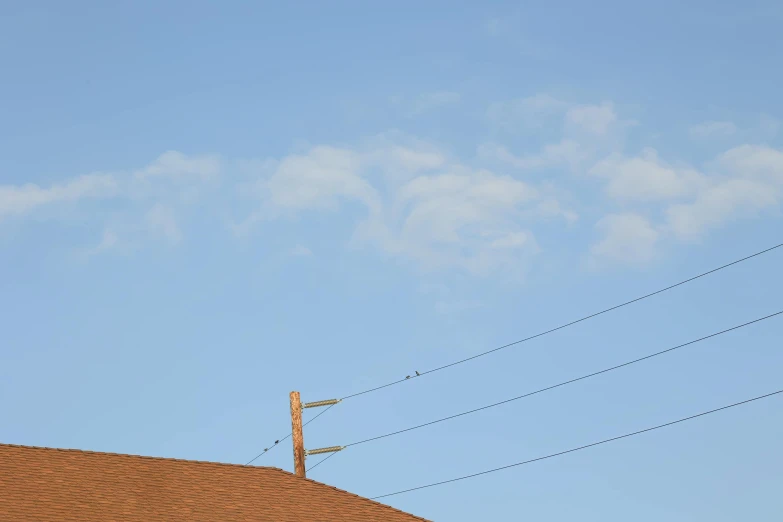 the view of a roof and telephone line in the daytime