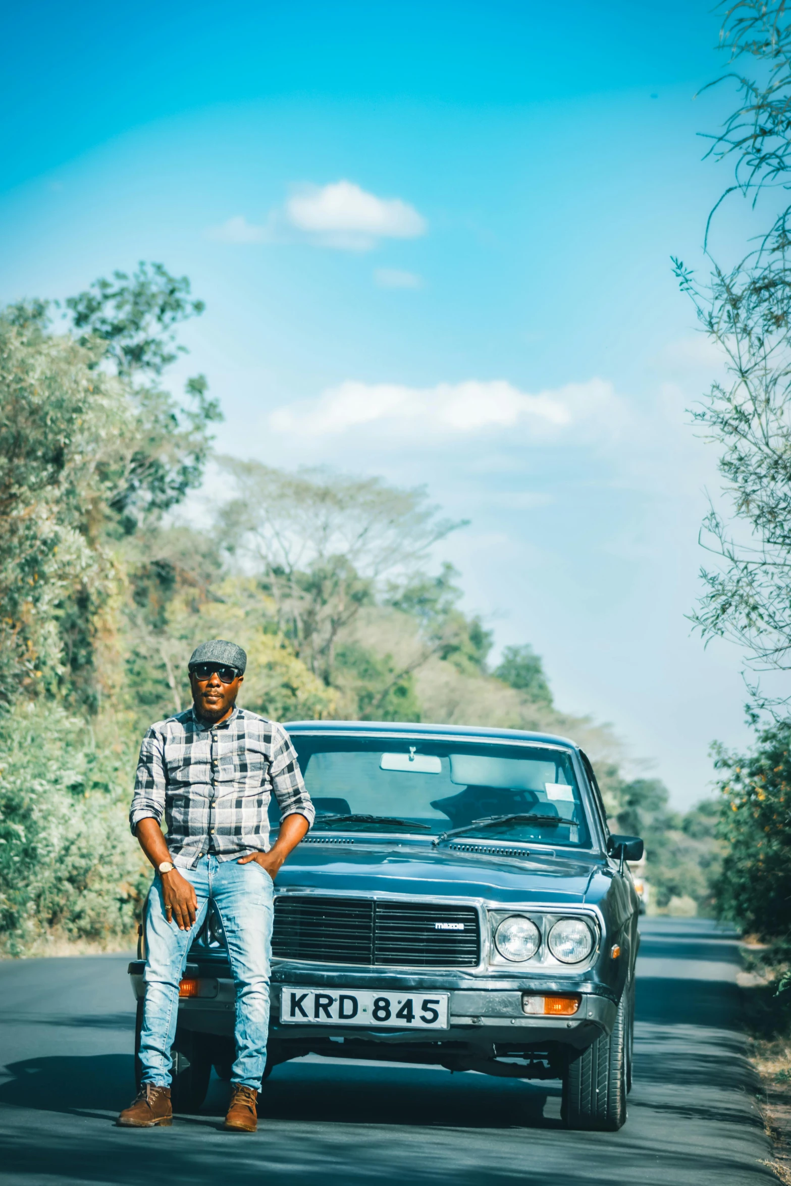 a black car is on a road with a man sitting on it