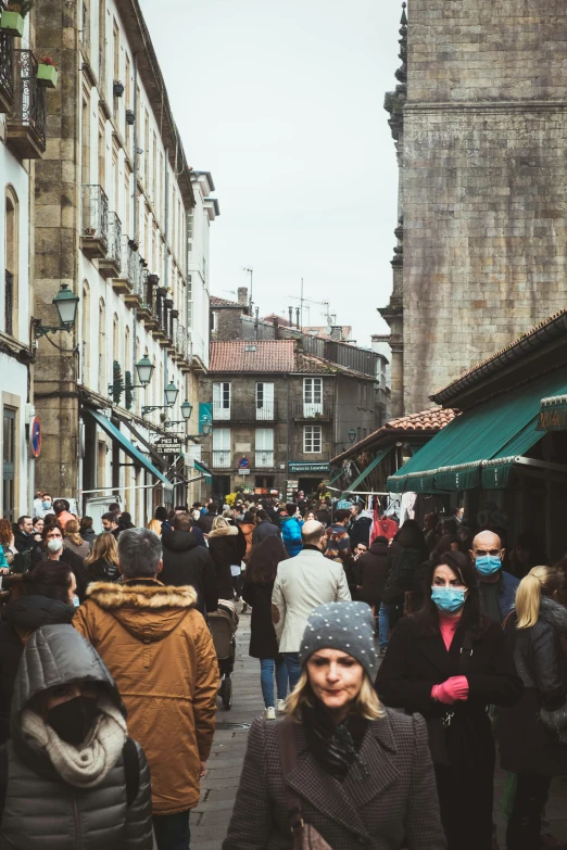 people walking through an old european street market