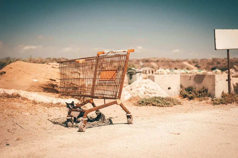 an old cart parked in the middle of a dirt field