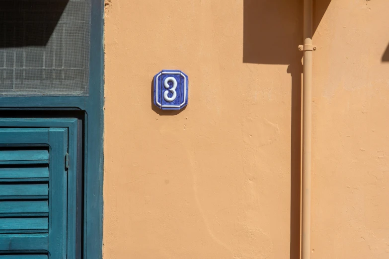 an odd blue number is on the side of a building