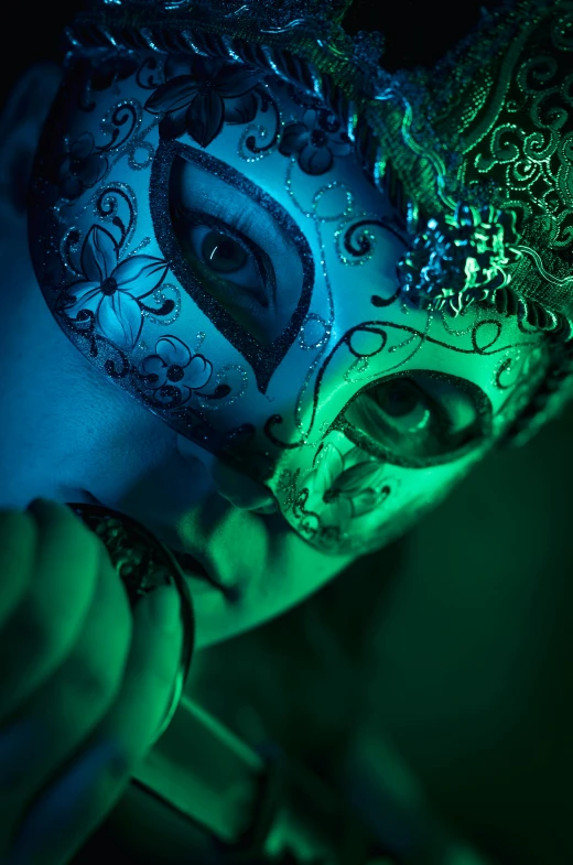 a woman in a green mask is lit up