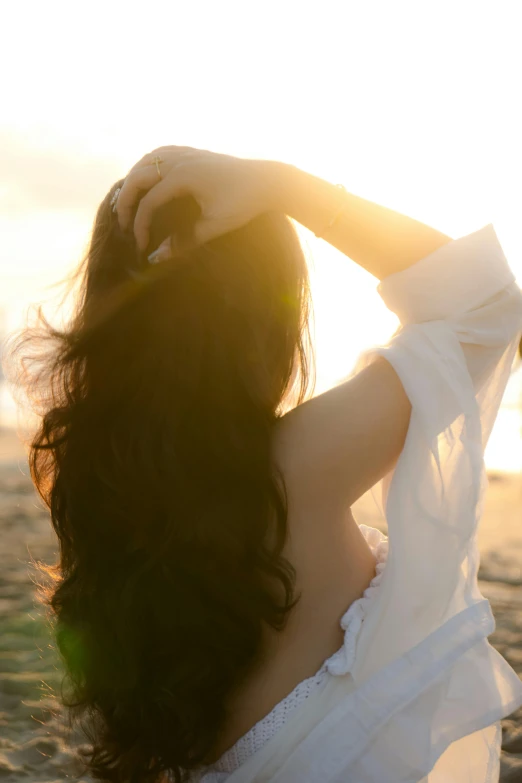 a woman wearing a white top in the sunset