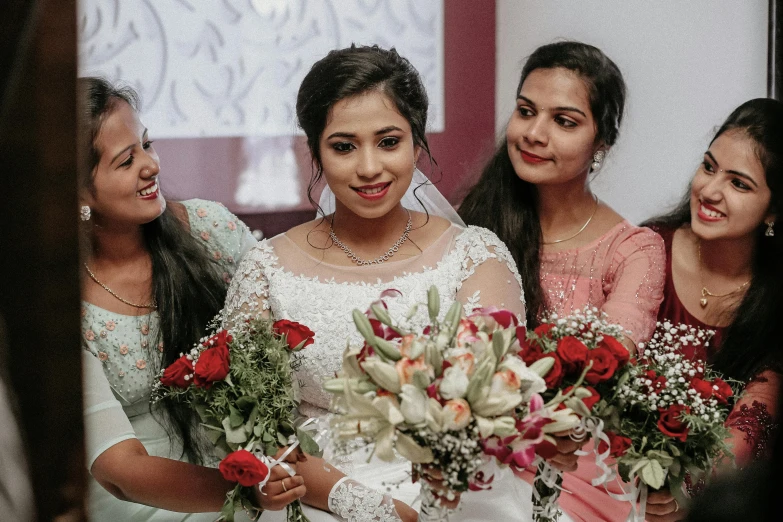 four brides laughing and holding their bouquets