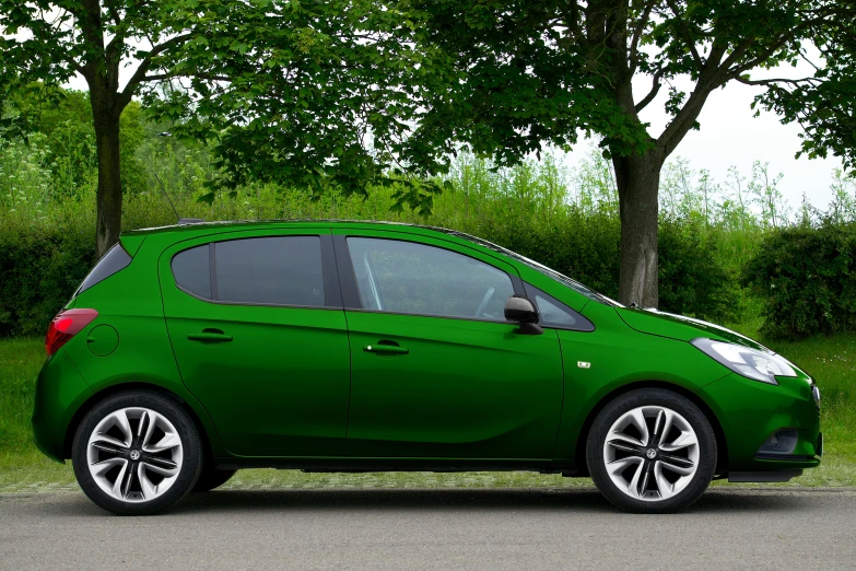 a green small car parked in front of some trees