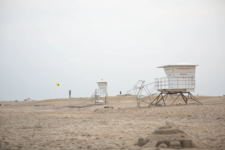 the lifeguard tower is surrounded by chairs and umbrellas