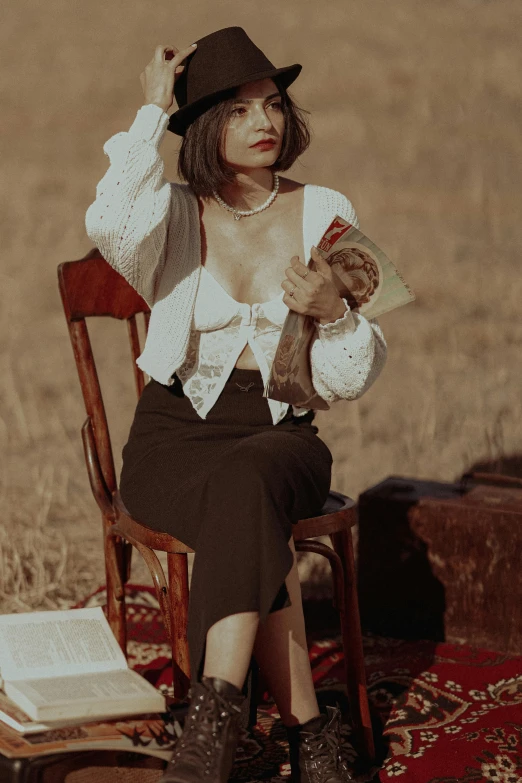 a woman is sitting on a wooden chair