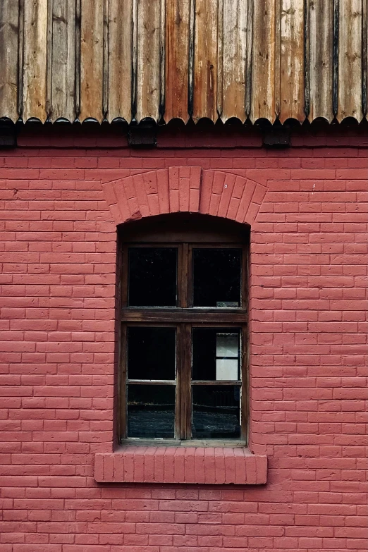 a window on top of a brick wall that has a wooden slatted roof