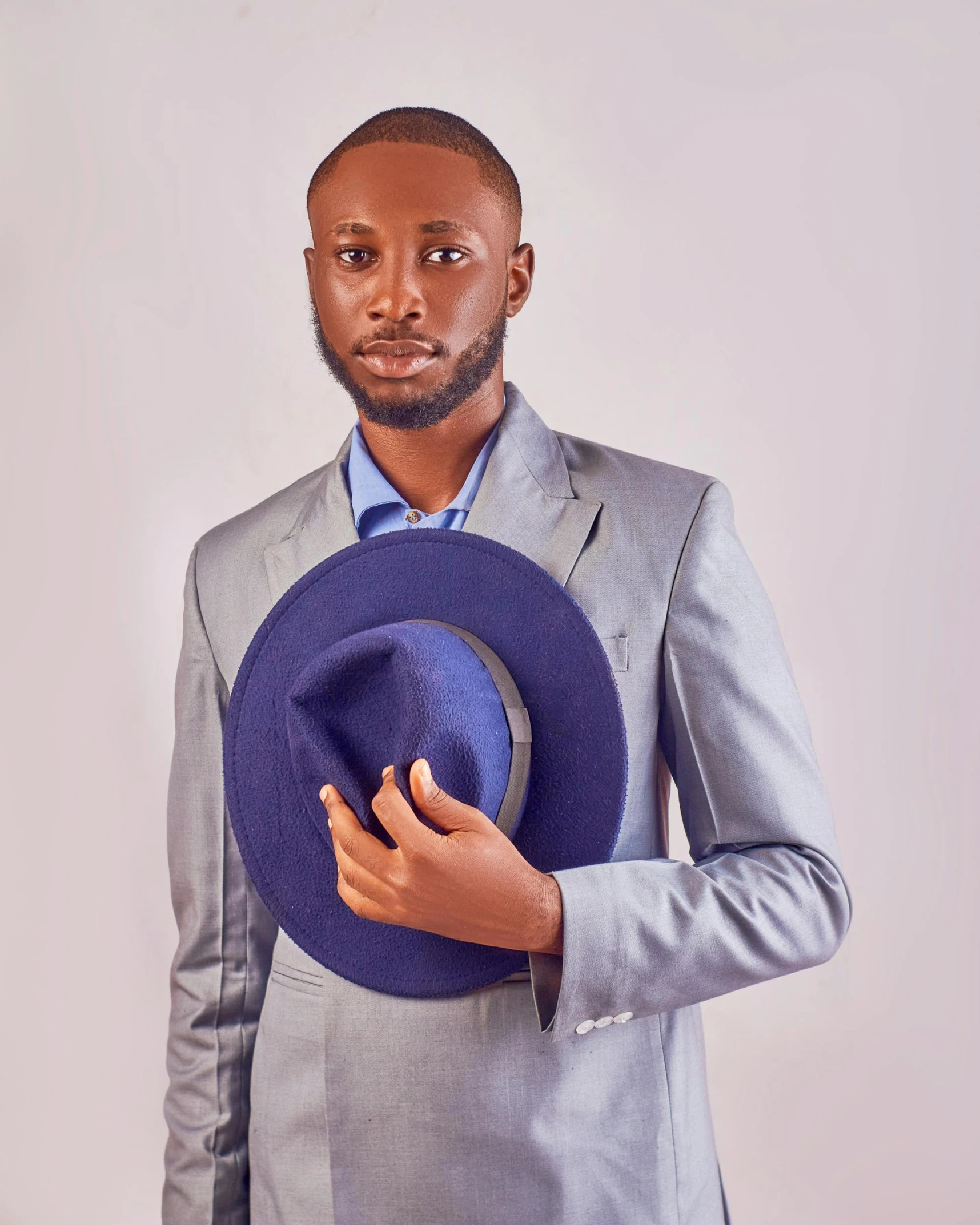 an african american man in a blue hat poses