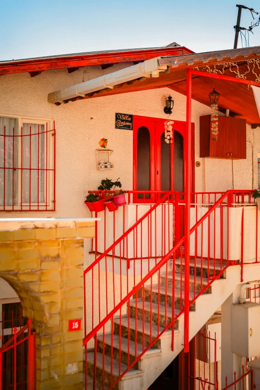 a red staircase and railing to a small house