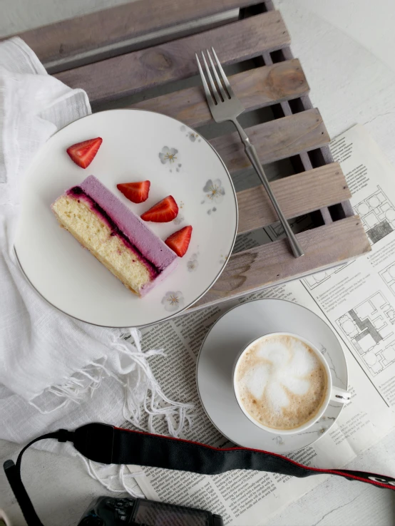 a piece of cake on a plate next to a coffee cup