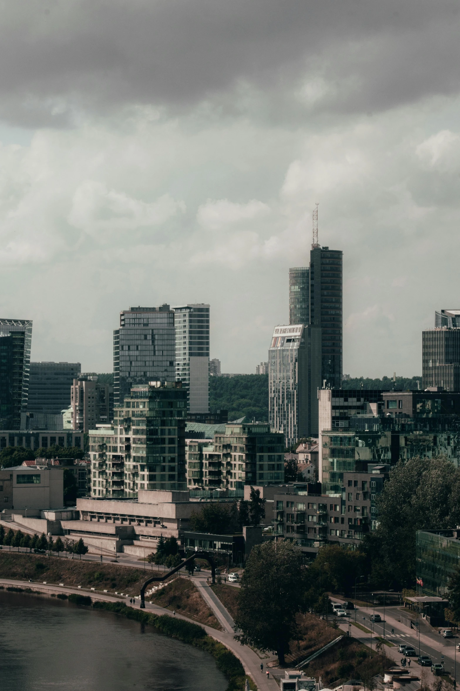 a city with buildings in the background, on a cloudy day