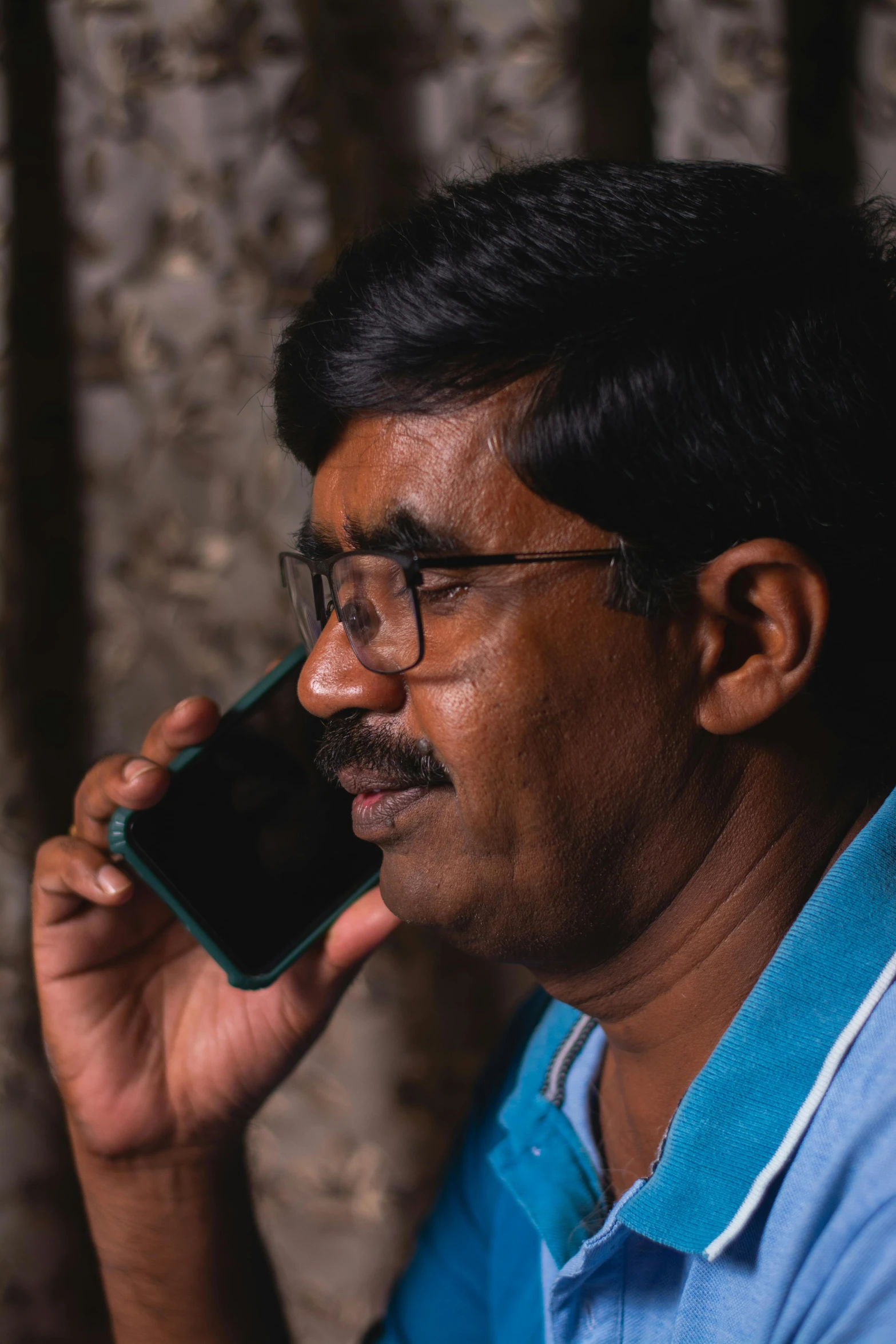 a man with glasses talking on a cell phone