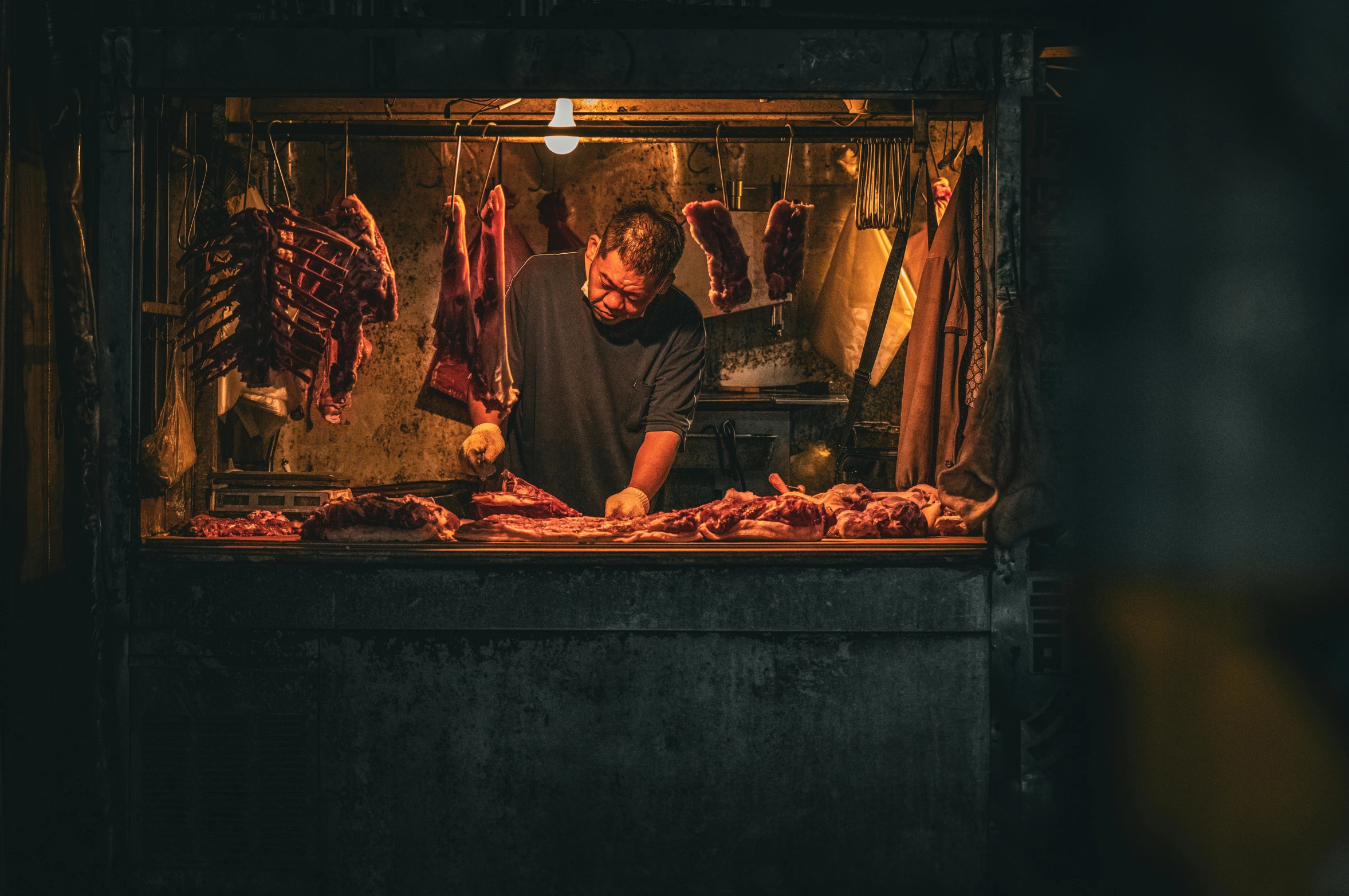 man grilling meat in a large bar inside of a building