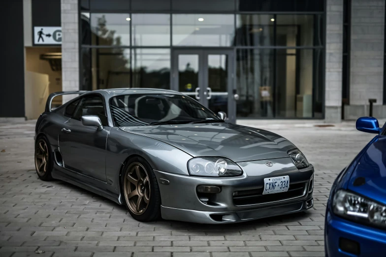 a silver sports car parked outside of a building