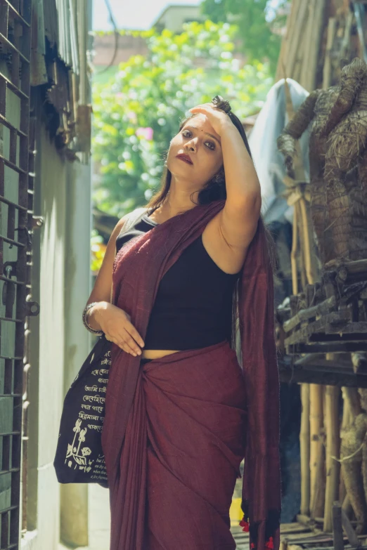 a woman in sari leaning against the wall