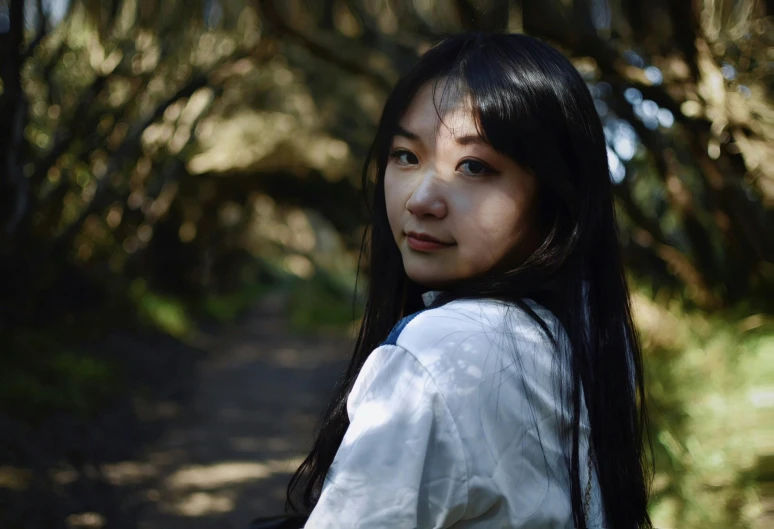 a girl standing in the middle of a forest