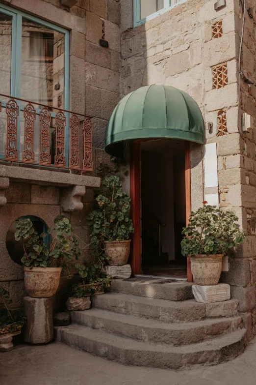 a beautiful door in the stone building with plants outside