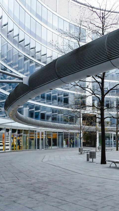 the walkway in a building has a curved metal canopy above it