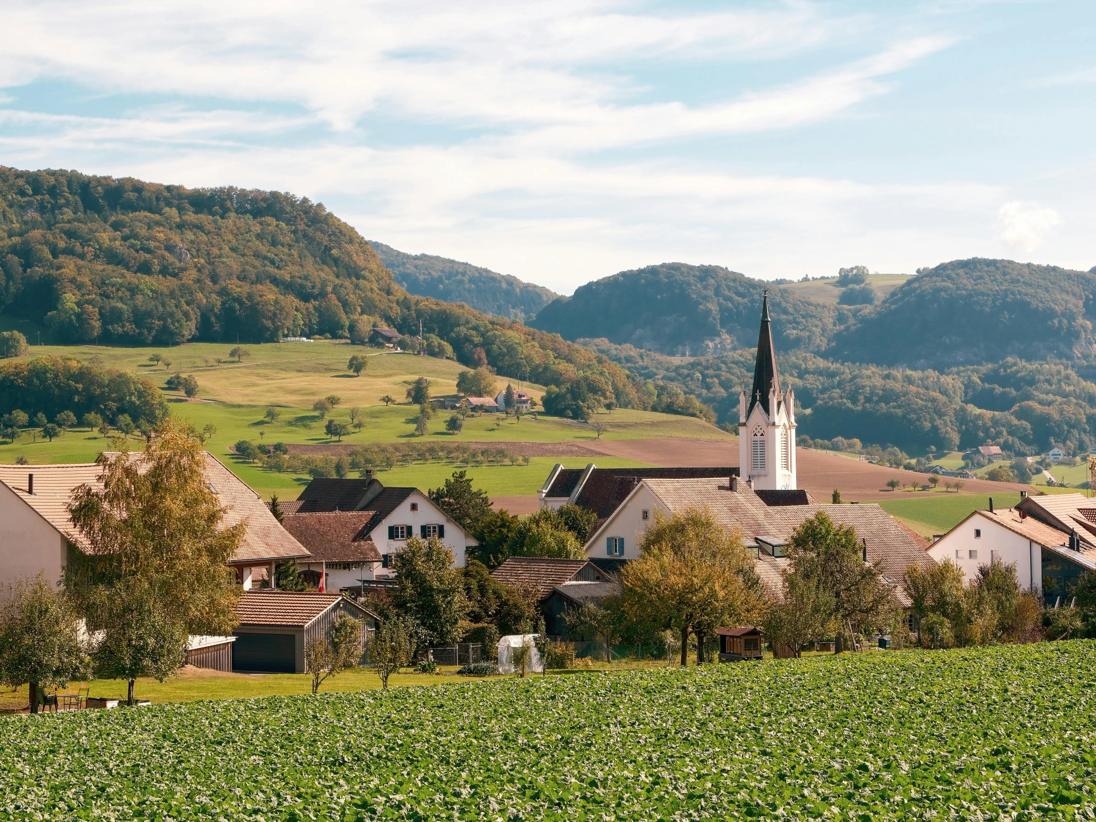 a town in the country with hills in the background