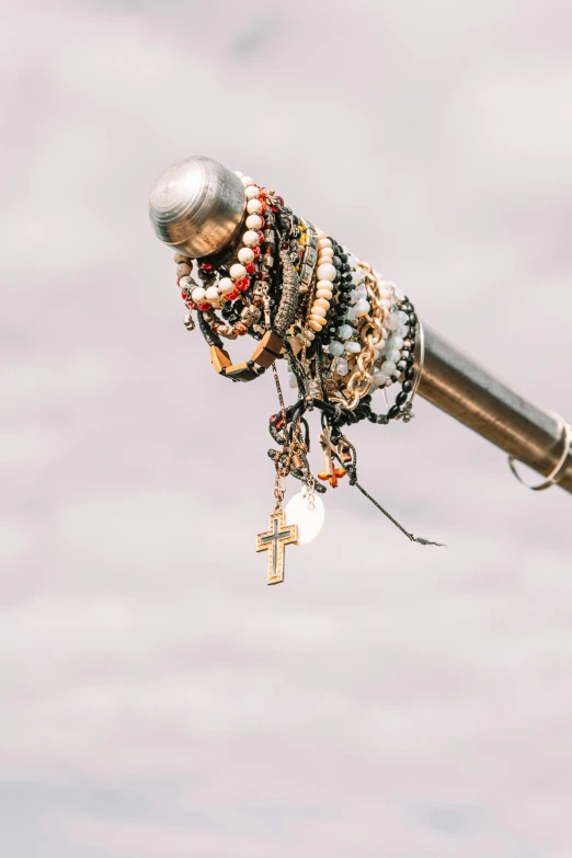 a silver, wooden and metal tube with beads on it