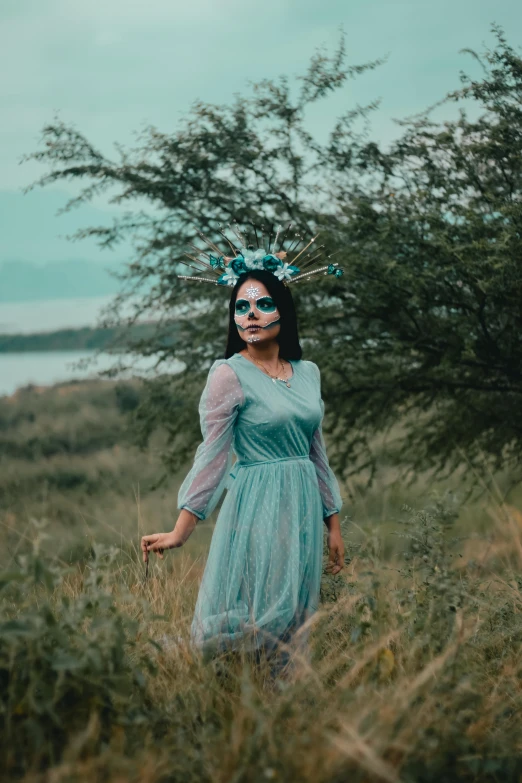 the woman has blue makeup and blue dress on