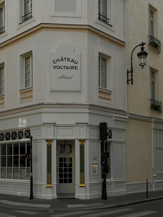 white, stone building with yellow trim on the corner