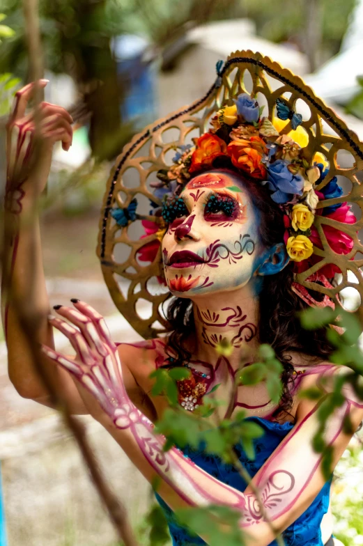 a woman in blue body paint with an umbrella hat on