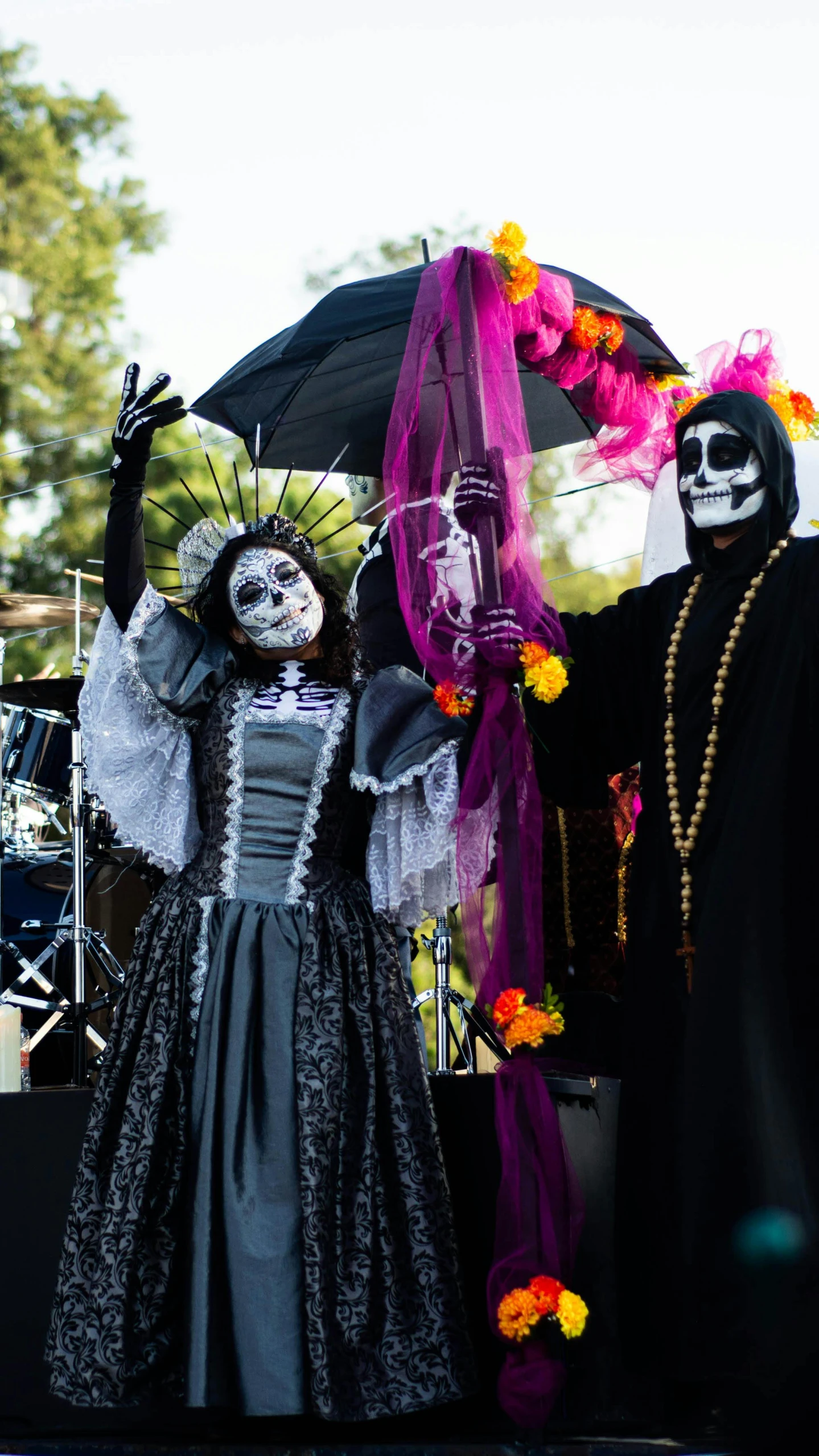 two people dressed in skeleton makeup with an umbrella